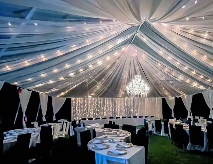chandelier in draped tent with table settings