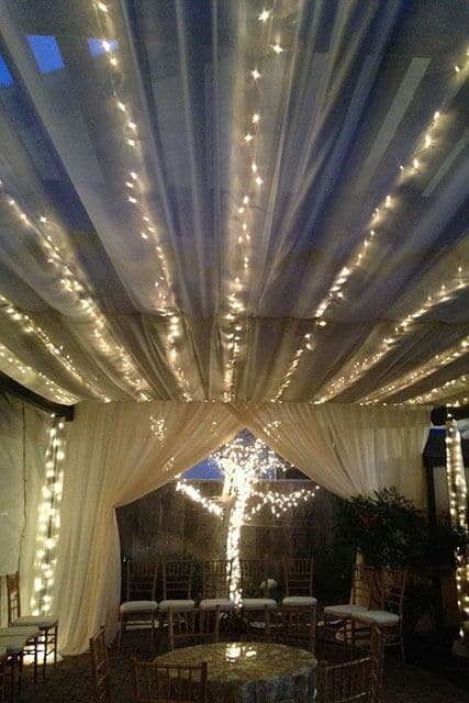 outdoor party tent at night with white string lights