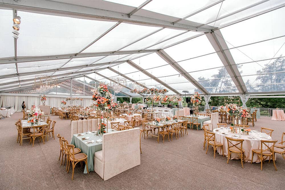 outdoor winter wedding reception under clear tent with table settings