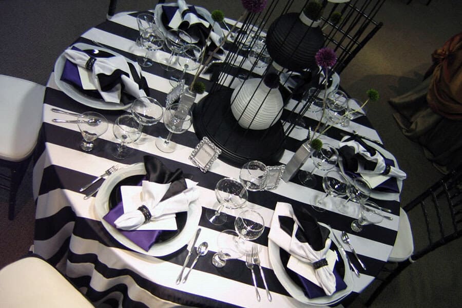 rented round table with chairs and black and white patterned linens for birthday party