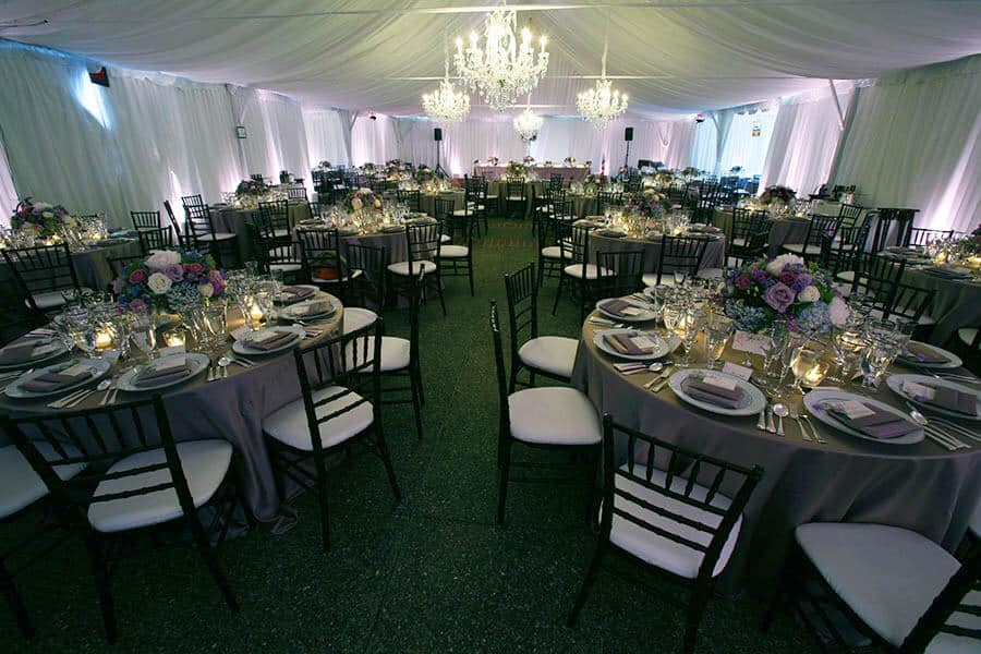 wedding reception with tables and decorative lighting inside framed tent for outdoor bay area wedding