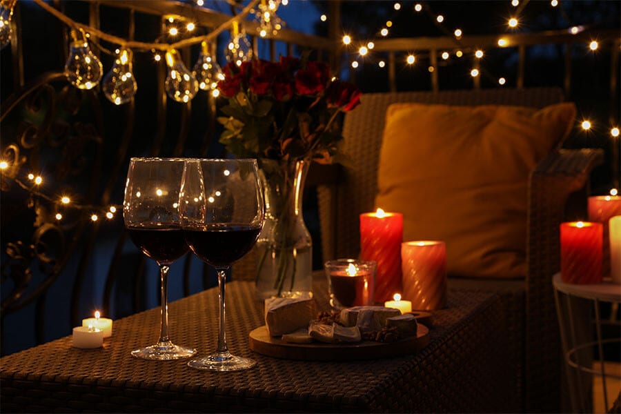 outdoor evening wine and cheese party with string lighting tables chairs and decorations