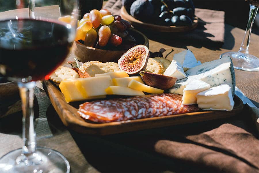 wine and cheese party snacks and hors d'oeuvres served on fancy wooden serving trays