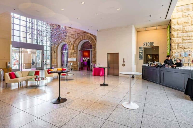 Event lobby with black filigree bar, ivory lounge furniture, and marble cocktail tables in black and white