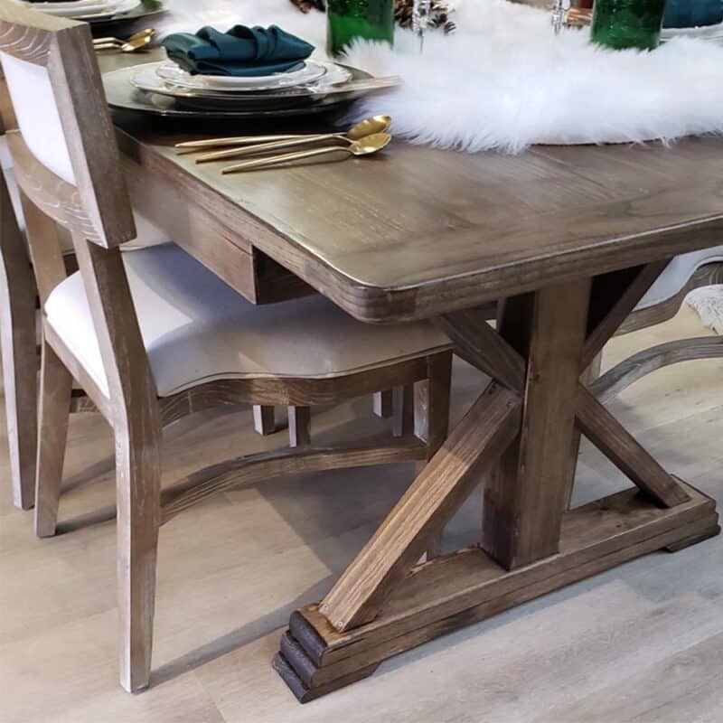 Grand Heritage Farmhouse Table with light-brown stain, satin finish, and trestle base, set for dining