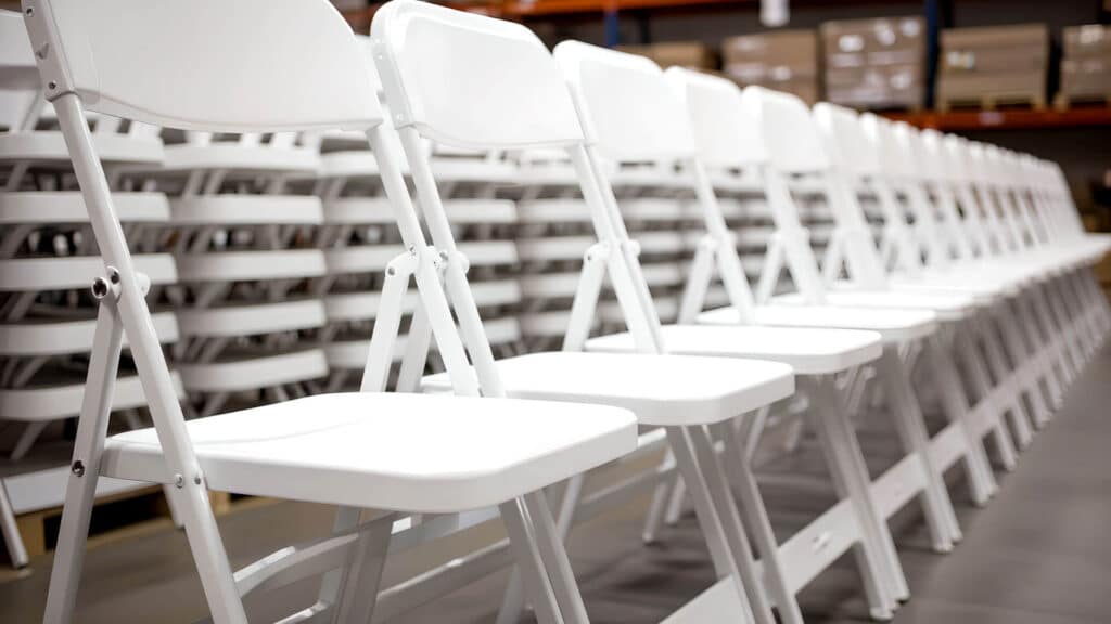 folding white chairs neatly arrange in rental warehouse